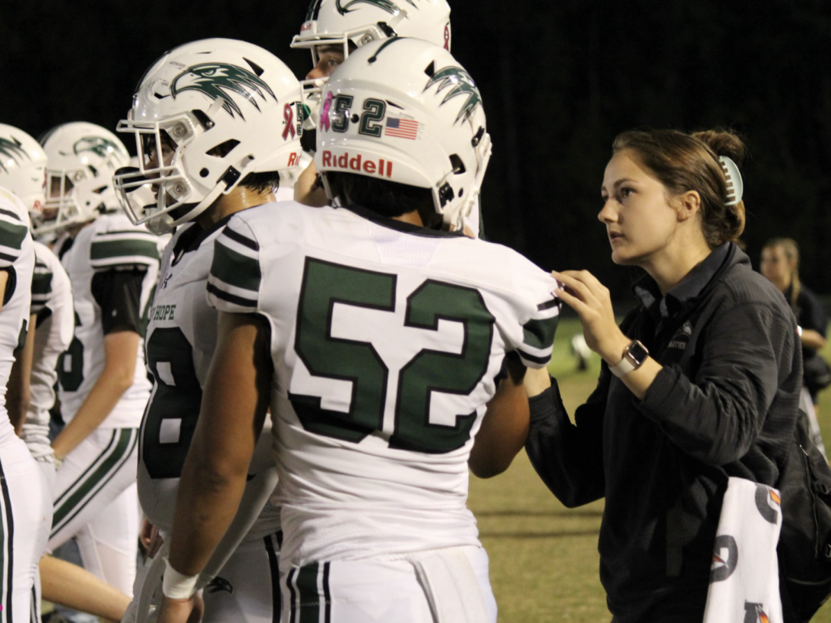 Ms. Maura Gaffney tends to football players during a game. 